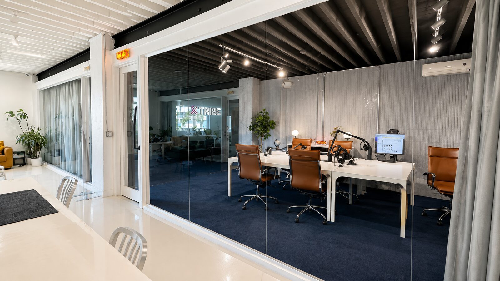 Sound-treated podcast studio with desks and microphones
